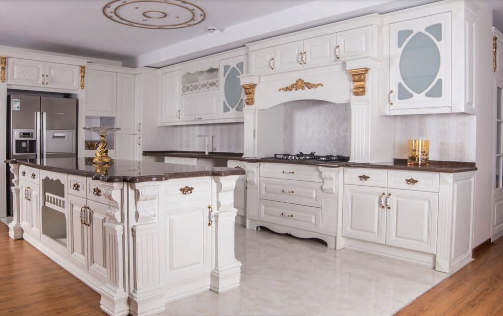 کابینت سفید صدفی ممبران کلاسیک با جزیره و منبتکاری طلایی و صفحه کابینت مشکی