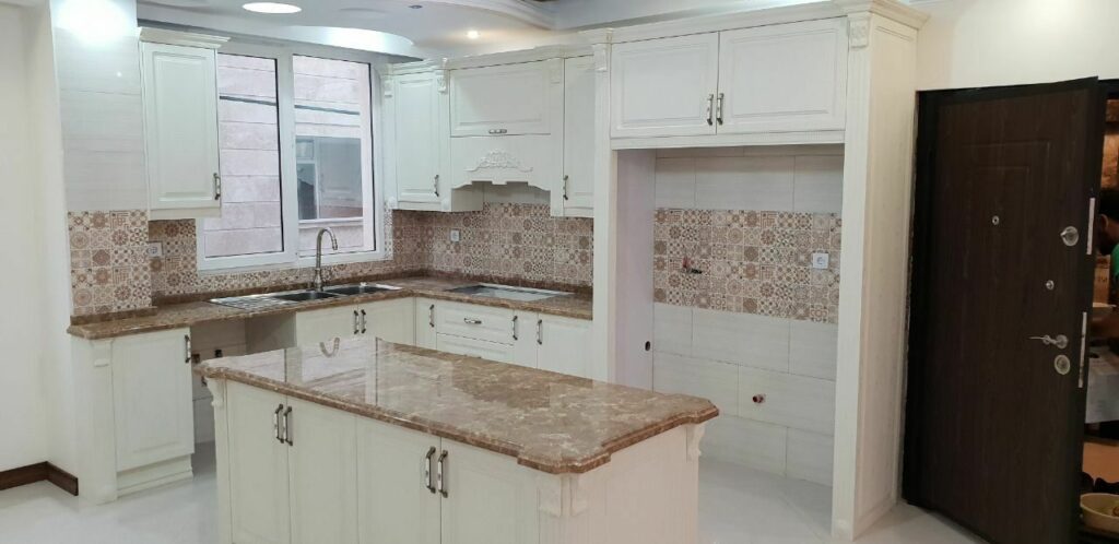 کابینت ممبران و جزیره کلاسیک سفید صدفی با صفحه کابینت سنگی قهوهای روشن