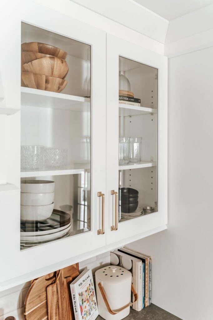 کابینت شیشه ای با بدنه سفید، دستگیره طلایی و شیشه ساده