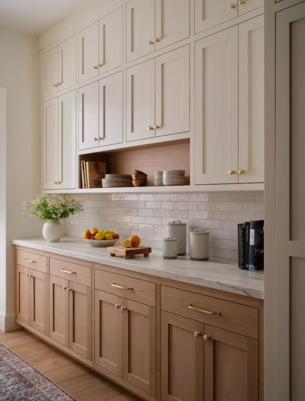 کابینت نئو کلاسیک دو رنگ چوب با دستگیرههای طلایی و صفحه کابینت و بین کابینتی سفید