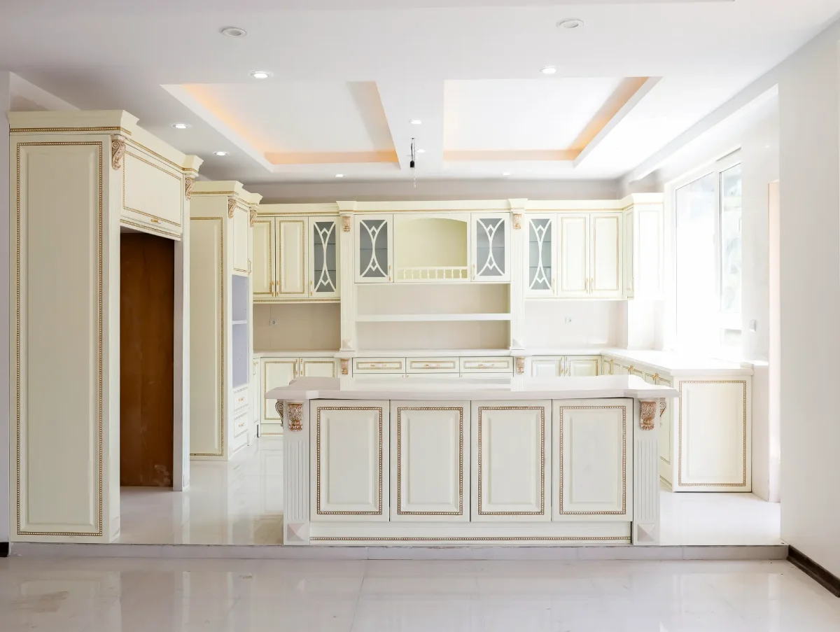 کابینت کلاسیک سفید چوبی با رگههای طلایی و جزیره با صفحه کابینت سفید و کابینت کمدی با فر تو کار