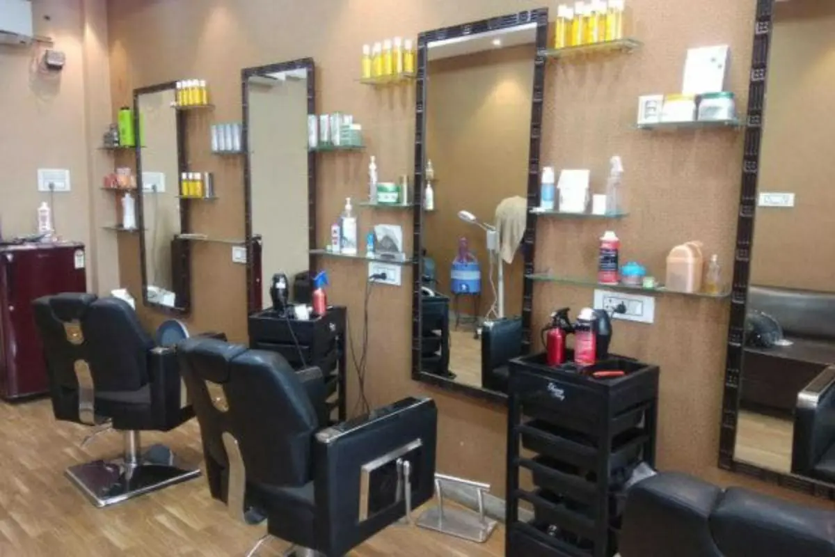 آرایشگاه مردانه مدرن با صندلی چرمی مشکی، آینه قدی مشکی و شلف شیشهای