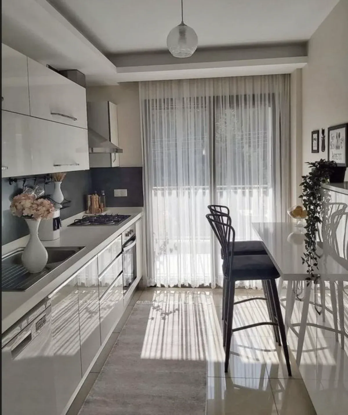 آشپزخانه با پرده حریر سفید نازک و کابینتهای هایگلاس سفید
