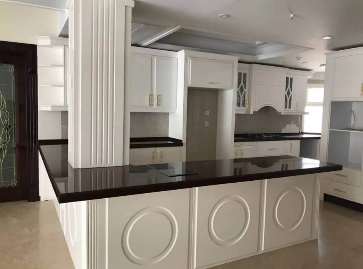 کابینت سفید انزو با منبتکاری روی کانتر آشپزخانه با صفحه کابینت مشکی
