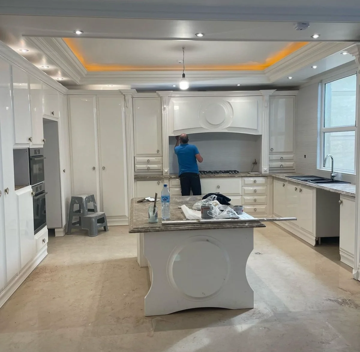 کابینت پولیشی انزو سفید با جزیره همراه کندهکاریهای ظریف روی جزیره و درب کابینت