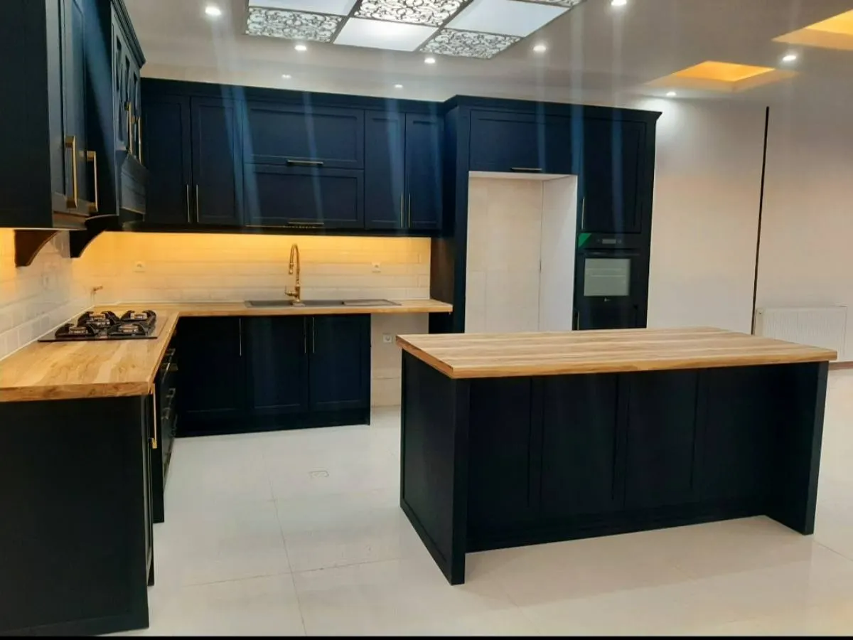 کابینت سبک نئوکلاسیک به رنگ مشکی با دستگیرههای طلایی