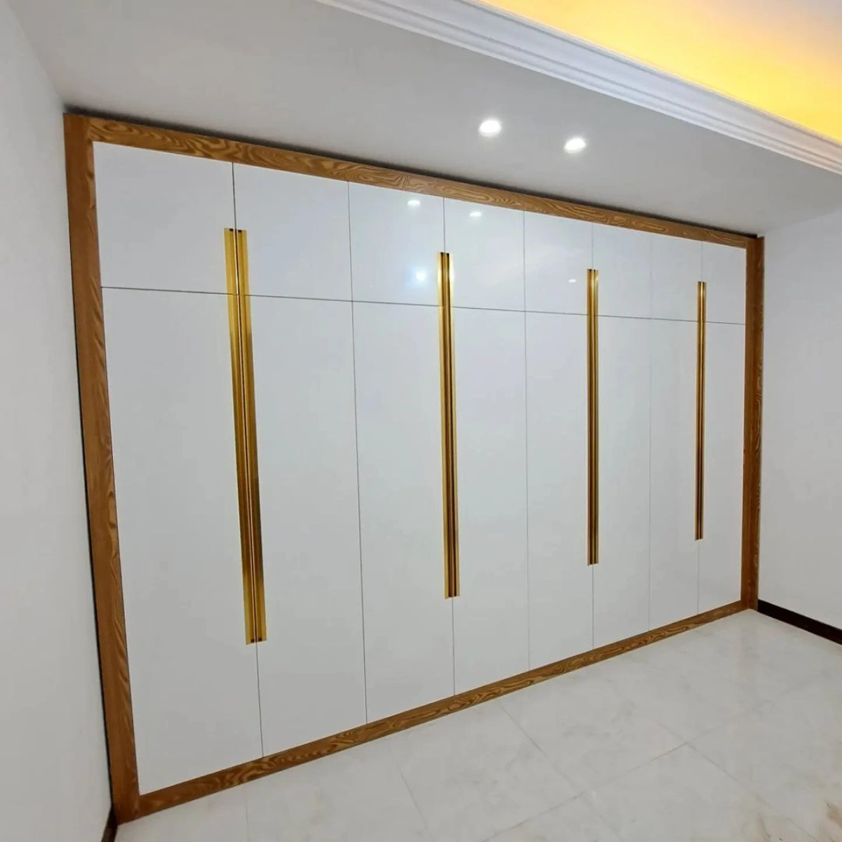 کمد دیواری ام دی اف سفید با چارچوب قهوه ای و دستگیره توکار به رنگ طلایی