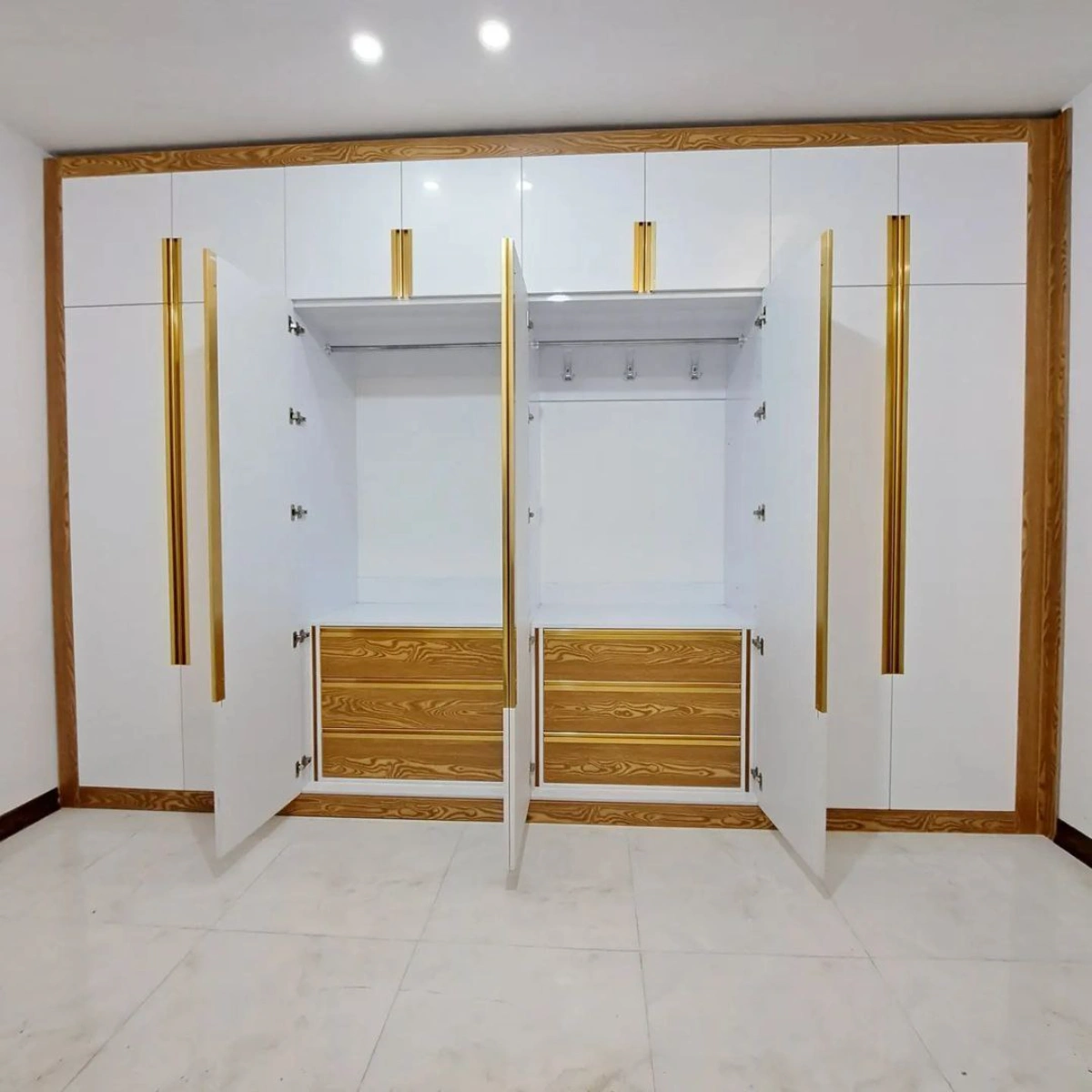فضای داخلی کمد دیواری ام دی اف سفید با کشوهای طلایی و دستگیره توکار طلایی