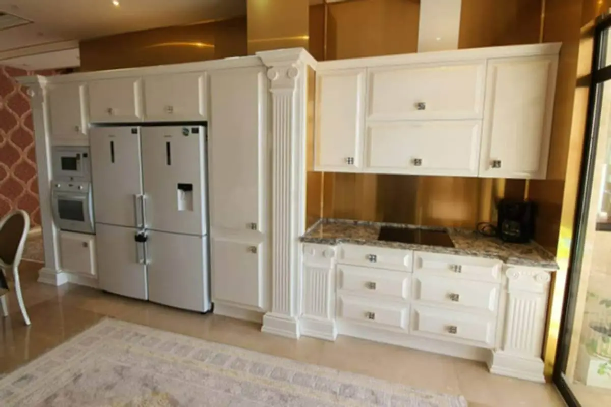 کابینت انزو سفید با ستونهای منبتکاریشده و بینکابینتی طلایی