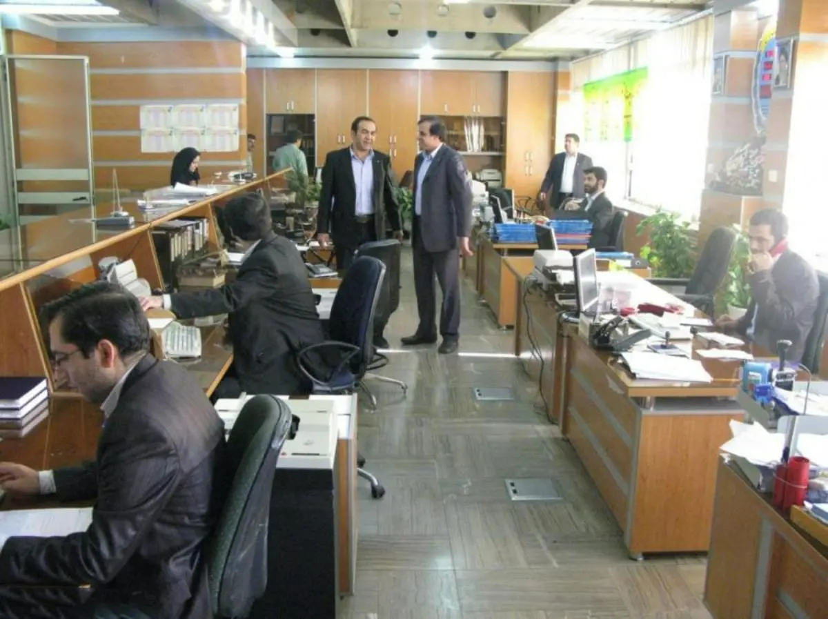 فضای کار کارمندان بانک با صندلی مشکی و میز قهوهای