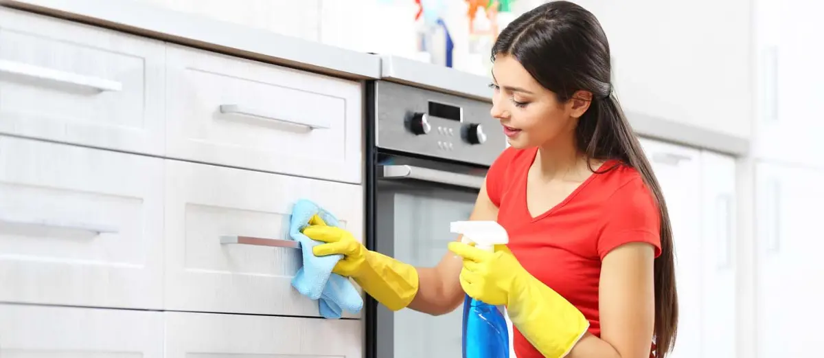 استفاده از اسپری محلول مایع ظرفشویی و آب برای تمیزکاری کابینت کنار گاز